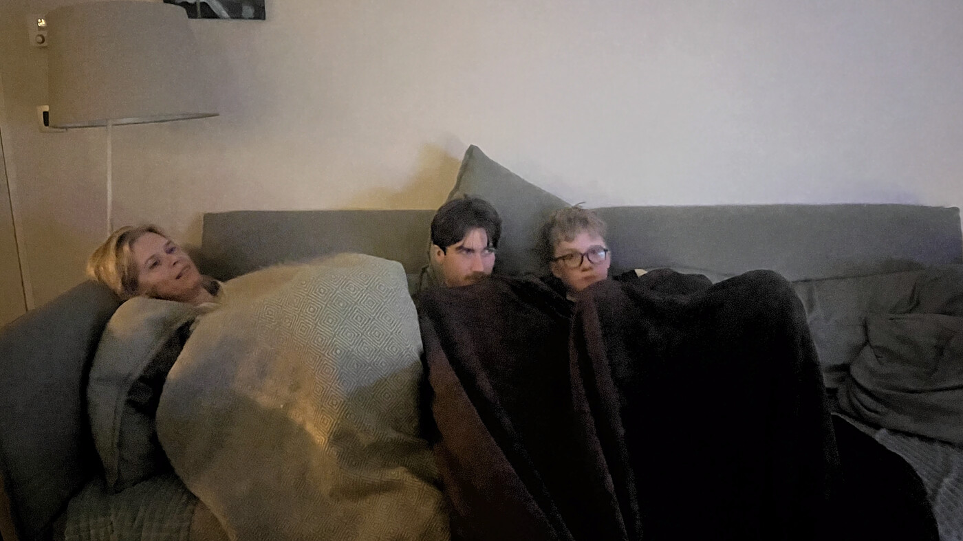 Ade is wrapped in a blanked with her familiy to stay warm